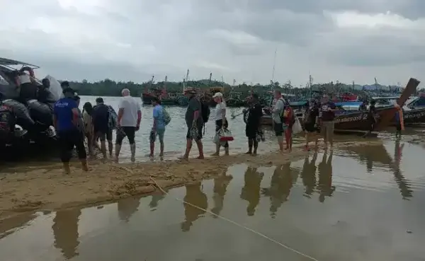 туристы садятся в катер с пляжа